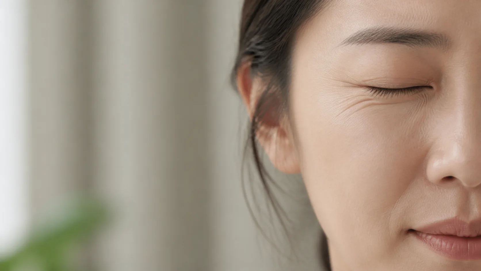 한쪽 눈과 입가에 반복되는 당김을 확인하는 성인의 얼굴 근접 장면